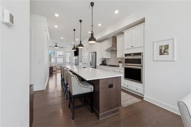 a kitchen with stainless steel appliances kitchen island granite countertop a sink a stove and a refrigerator