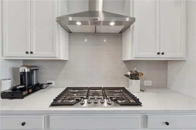 a kitchen with white cabinets and appliances