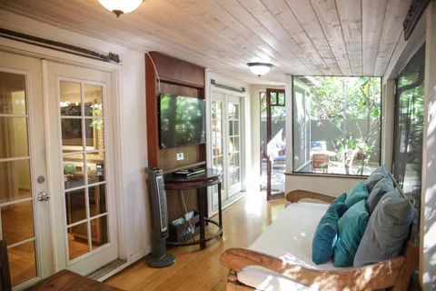 a living room filled with furniture and large windows