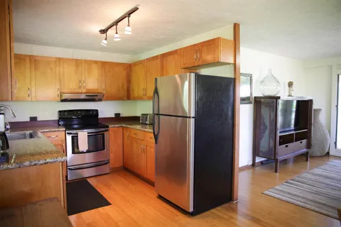 a kitchen with stainless steel appliances granite countertop a refrigerator a stove and a sink