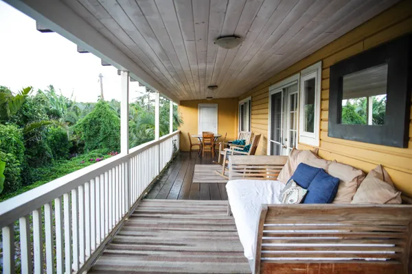 a view of a patio with couches chairs dining table and chairs with wooden floor