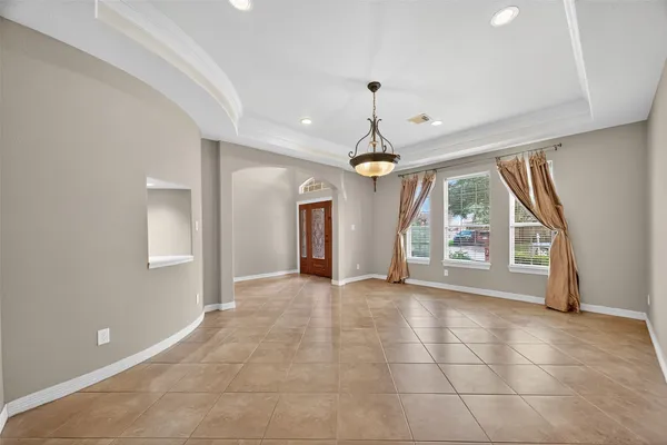 a view of a livingroom with a fireplace a ceiling fan and entryway