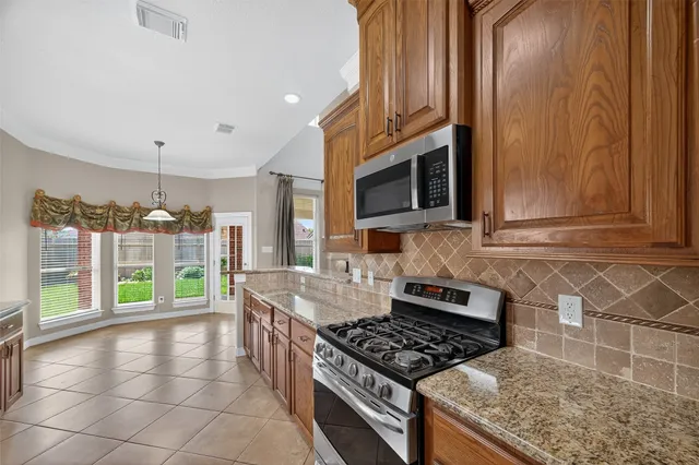 a kitchen with granite countertop a sink and a stove