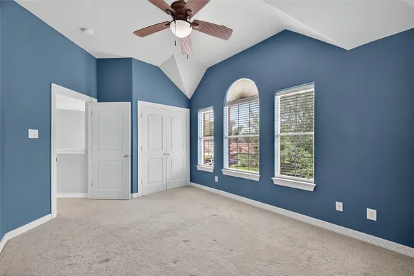 an empty room with closet and a chandelier fan