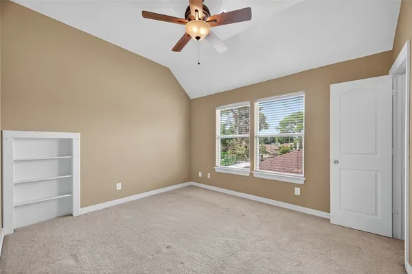 a view of an empty room with window and cabinet