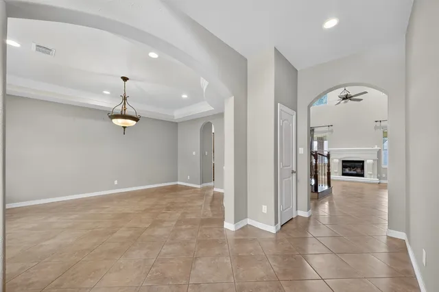 an empty room with fireplace and chandelier
