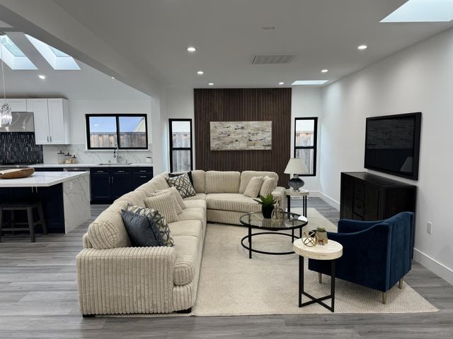 a living room with furniture a rug and a flat screen tv