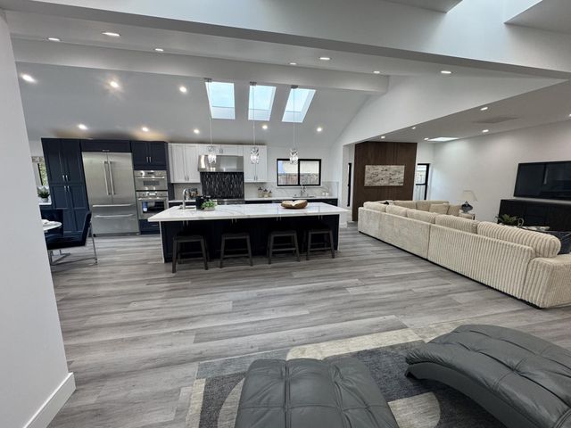 a living room with stainless steel appliances furniture or kitchen view and a chandelier