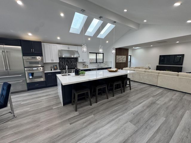 a large kitchen with cabinets table and chairs