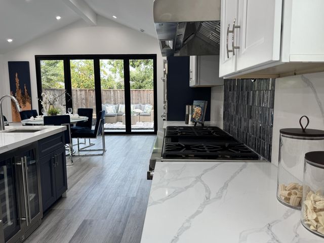 a kitchen with granite countertop a stove and a wooden floors