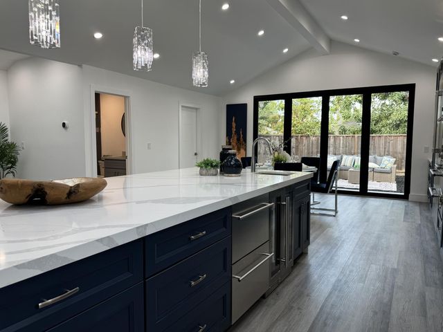 a kitchen with a sink a counter space appliances and a large window