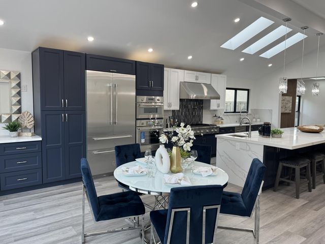 a kitchen with stainless steel appliances kitchen island granite countertop a kitchen island a stove a dining table and chairs