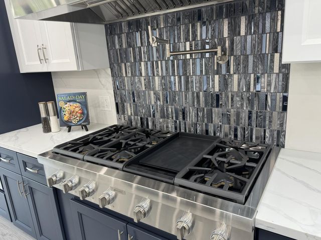 a stove top oven sitting inside of a kitchen