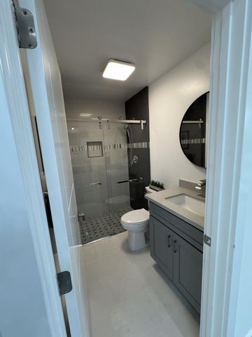 a bathroom with a granite countertop toilet sink and mirror