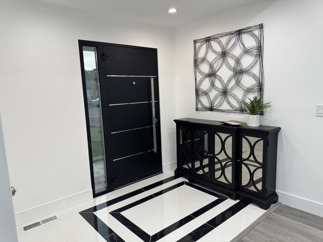 a view of an empty room with a wooden floor and a window