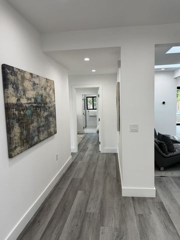 a view of a hallway with wooden floor and a couch