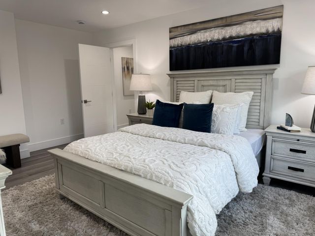 a bedroom with a bed and a painting on the wall