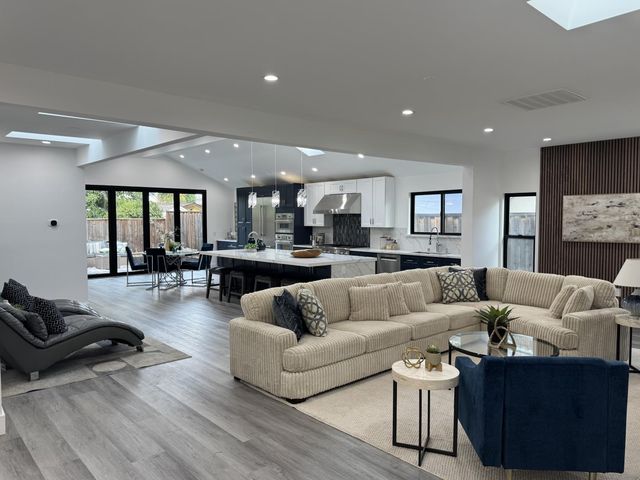 a living room with furniture and a view of kitchen