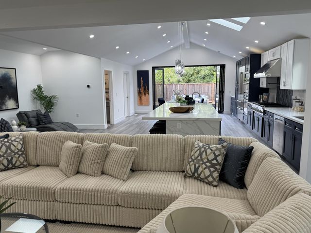 a living room with furniture kitchen and a large window