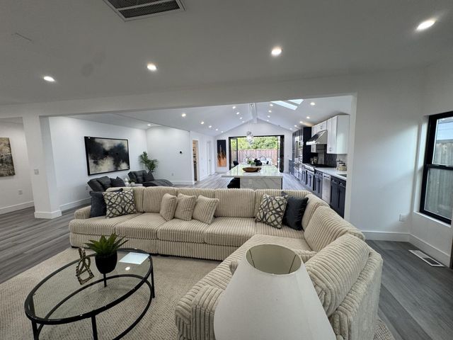 a living room with furniture and a wooden floor