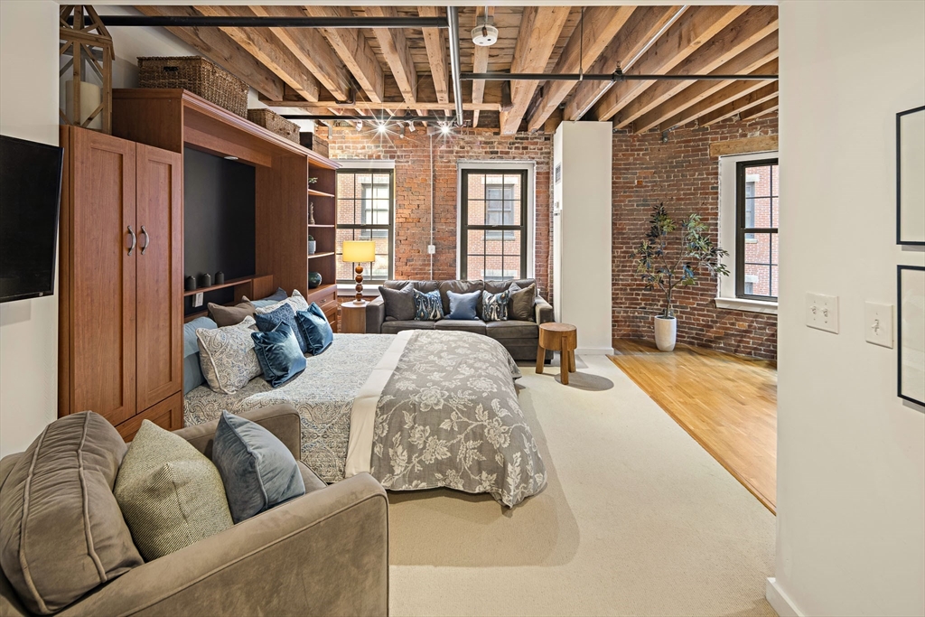 99-105 Broad Street, Unit 4F Boston, MA 02110 - Photo 3 of 16 a living room with furniture and a chandelier