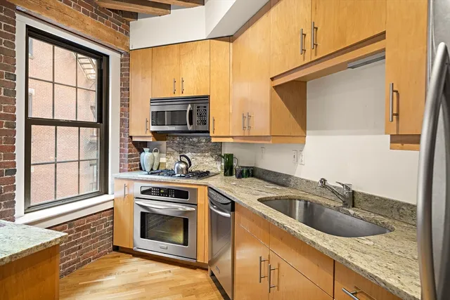 a kitchen with granite countertop a sink and a stove top oven