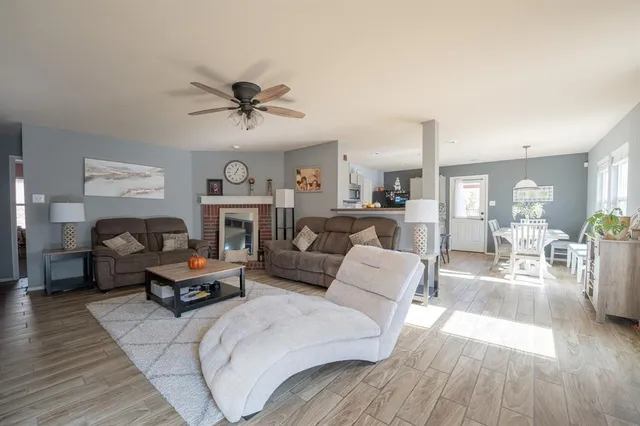a living room with furniture a fireplace and wooden floor