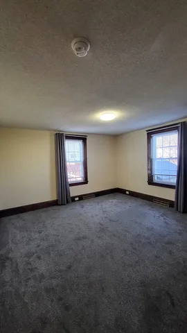 an empty room with a window and fireplace