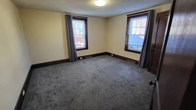 an empty room with windows and closet