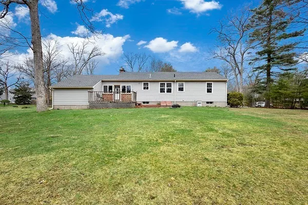 a big white house with a yard and parking space