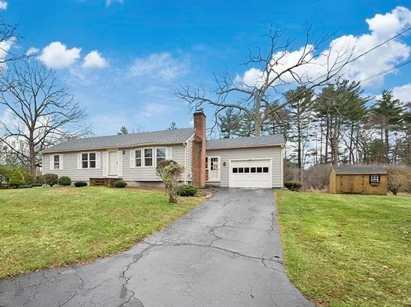 a view of a house with a yard and a large tree