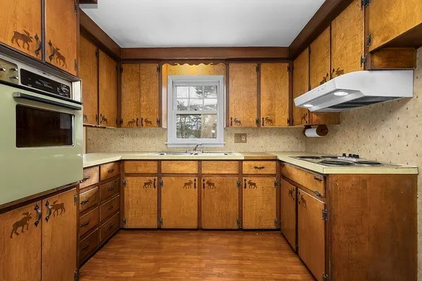 a kitchen with stainless steel appliances granite countertop a sink a stove and a refrigerator