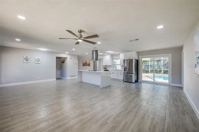 a large kitchen with stainless steel appliances granite countertop a large counter top and wooden floors