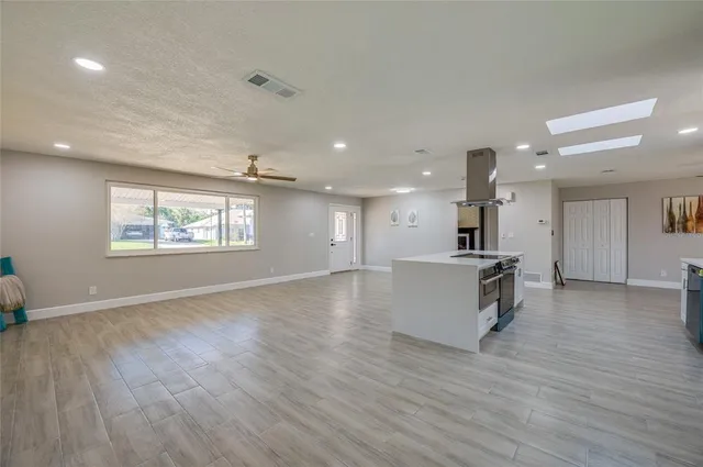 an empty room with wooden floor and ceiling fan