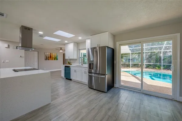 an empty room with wooden floor and ceiling fan