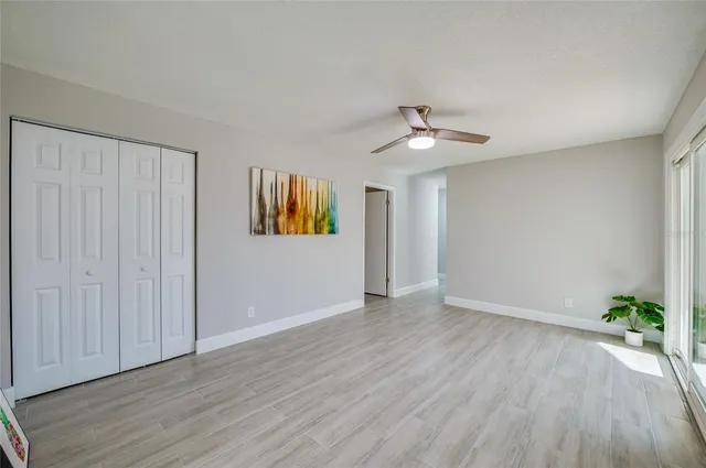 a view of a hallway with wooden floor and a kitchen