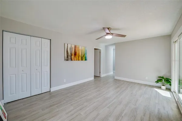 a view of a hallway with wooden floor and a kitchen
