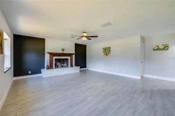 an empty room with wooden floor and ceiling fan