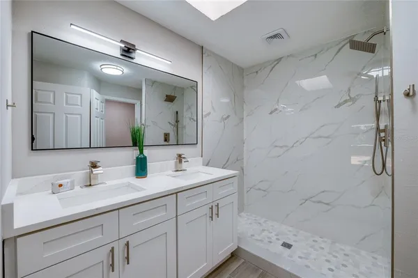 a bedroom with a large bed and a chandelier