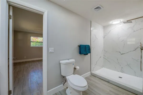 an empty room with wooden floor and ceiling fan
