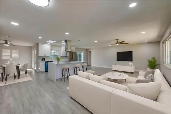 a view of kitchen with kitchen island a sink wooden floor and a refrigerator