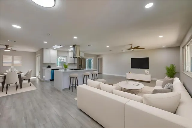 a view of kitchen with kitchen island a sink wooden floor and a refrigerator