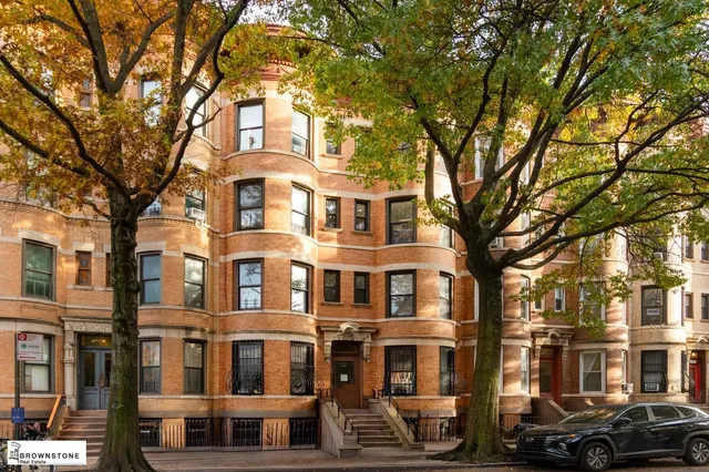 an empty room with windows and fireplace