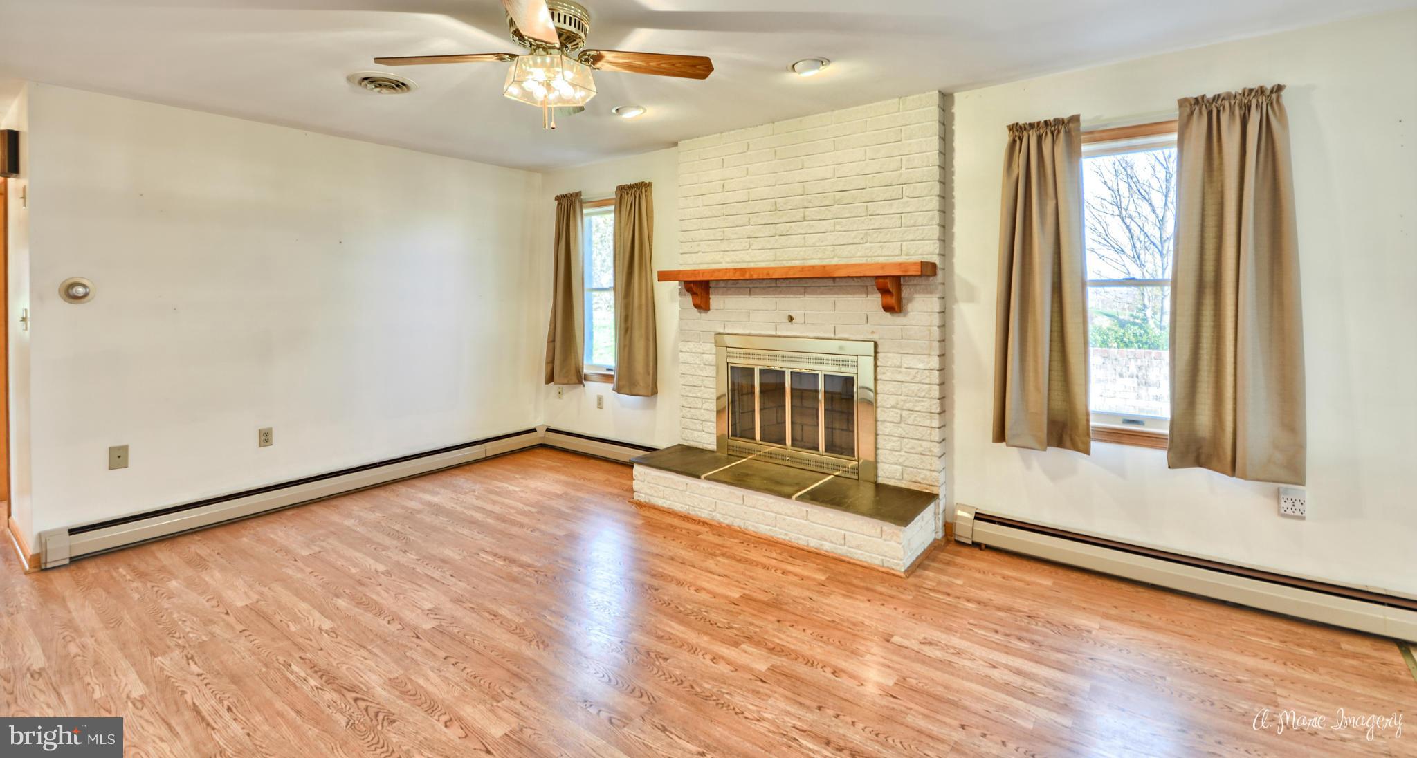 8021 Rocky Springs Road Frederick, MD 21702 - Photo 10 of 30 a view of a livingroom with wooden floor and a ceiling fan