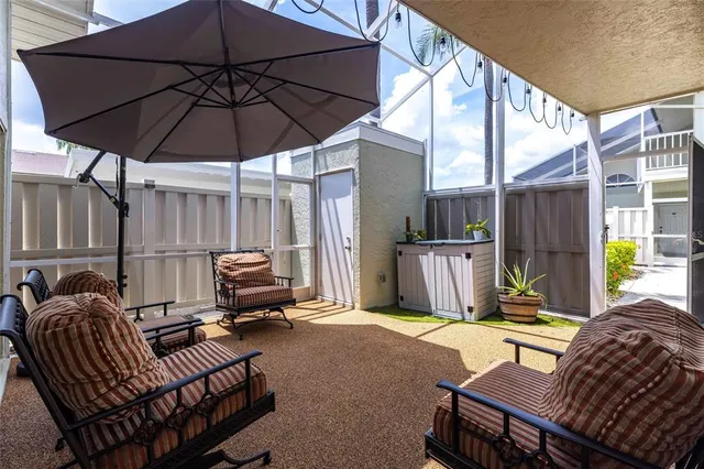a view of a patio with a table and chairs under an umbrella