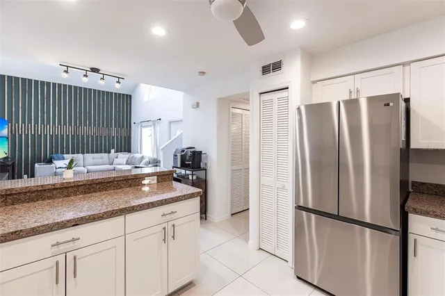a kitchen with stainless steel appliances granite countertop a refrigerator and a sink