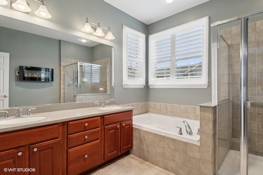 2846 Normandy Circle Naperville, IL 60564 - Photo 12 of 44 a bathroom with a granite countertop tub a sink and a large mirror