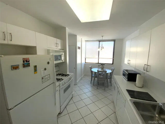a kitchen with a refrigerator a table and chairs in it