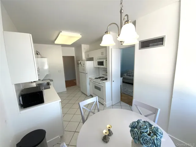 a kitchen with stainless steel appliances a stove a refrigerator and a wooden floor