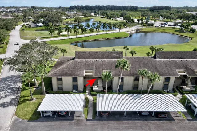 an aerial view of a house with a garden and lake view